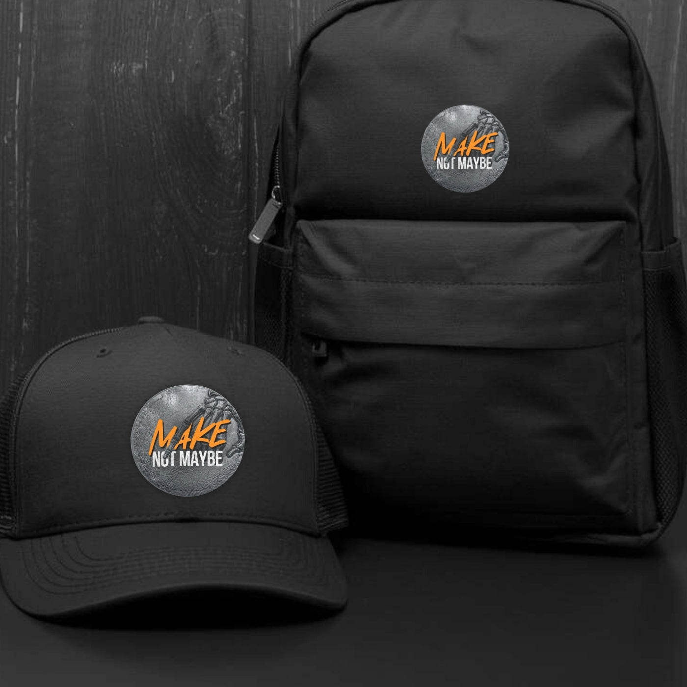 Runder Tech-Leather Patch „MAKE NOT MAYBE“ mit Klett auf der Rückseite auf einer Cap und Rucksack mit dunklem Hintergrund