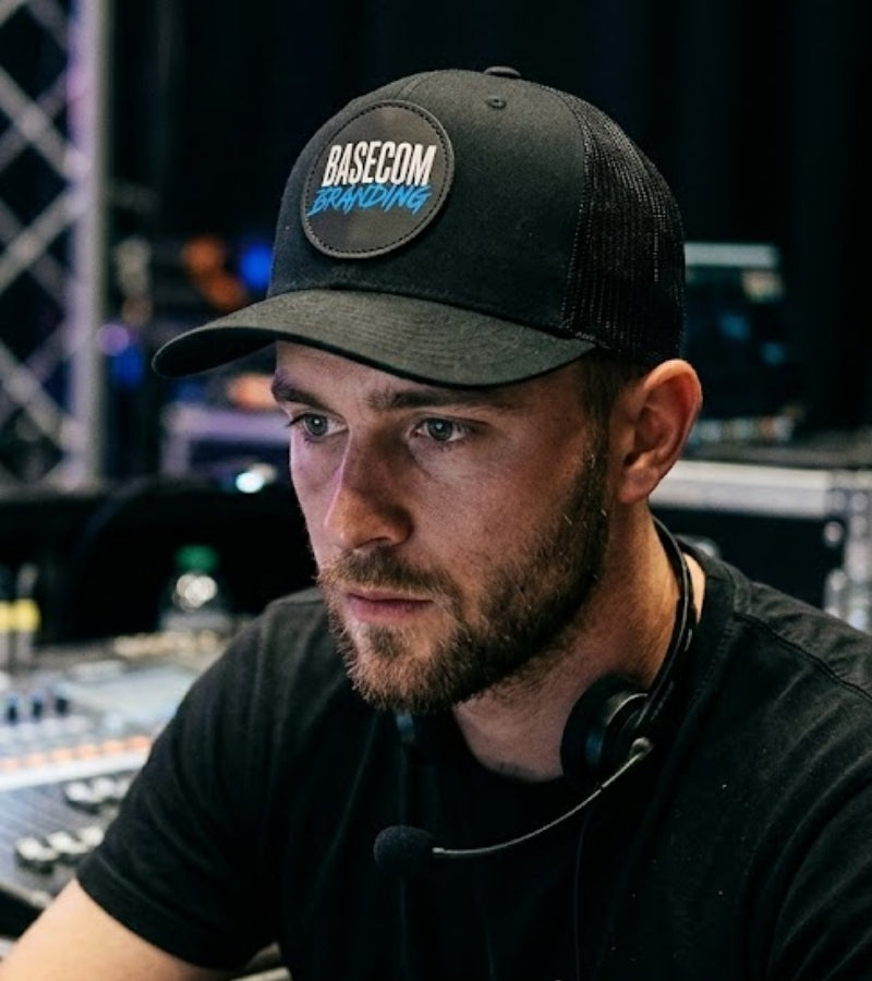 Event-Techniker mit schwarzer Cap an einem Mischpult